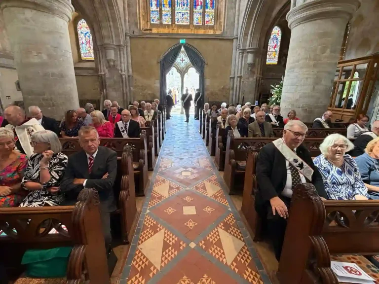 The members (in their Masonic Regalia) and their families seated in St Cross Church awaiting the procession of the Heads of Orders prior to the start of the Service